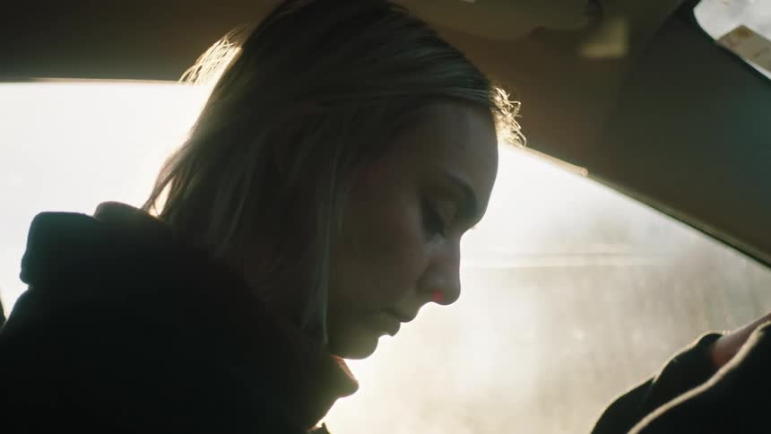 Silhouette of an anxious woman sitting inside a car