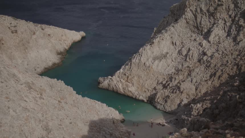 People spend time at narrow beach between slopes