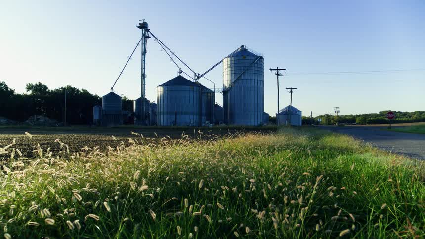 Smooth shot of agricultural grain storage towers on a cloudless morning in the American Midwest