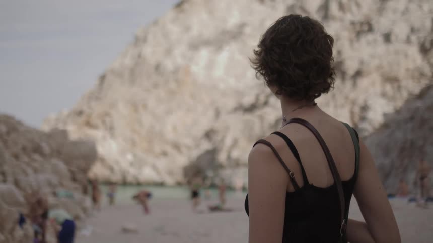 Woman on the sandy beach next to the seashore