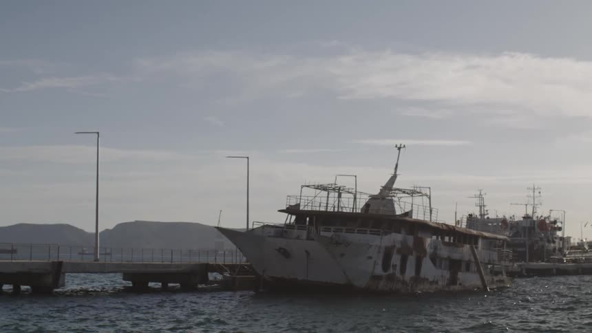 Abandoned ship docked at a pier