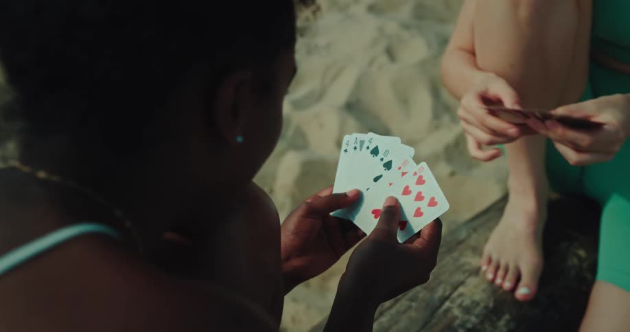 Friends playing cards on the beach on a summer day