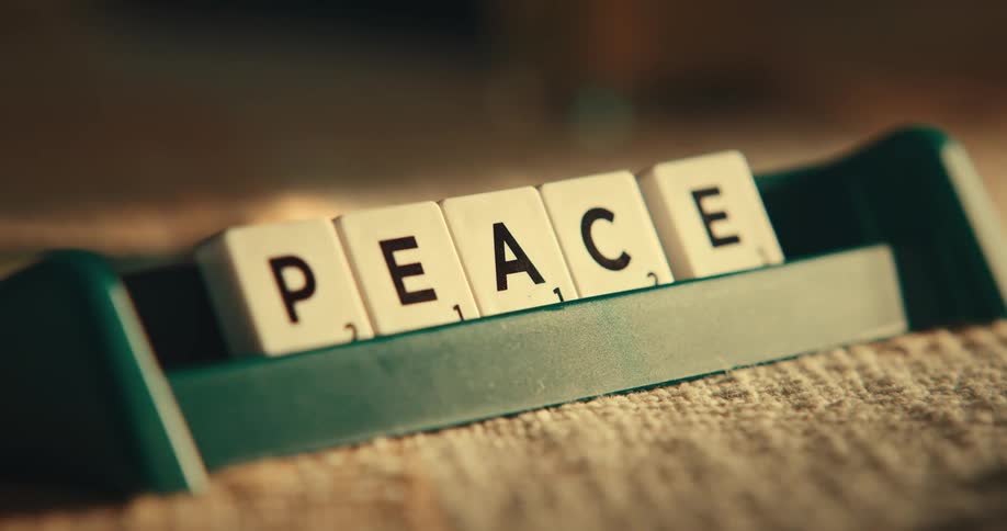 A finger dropping scrabble letters
