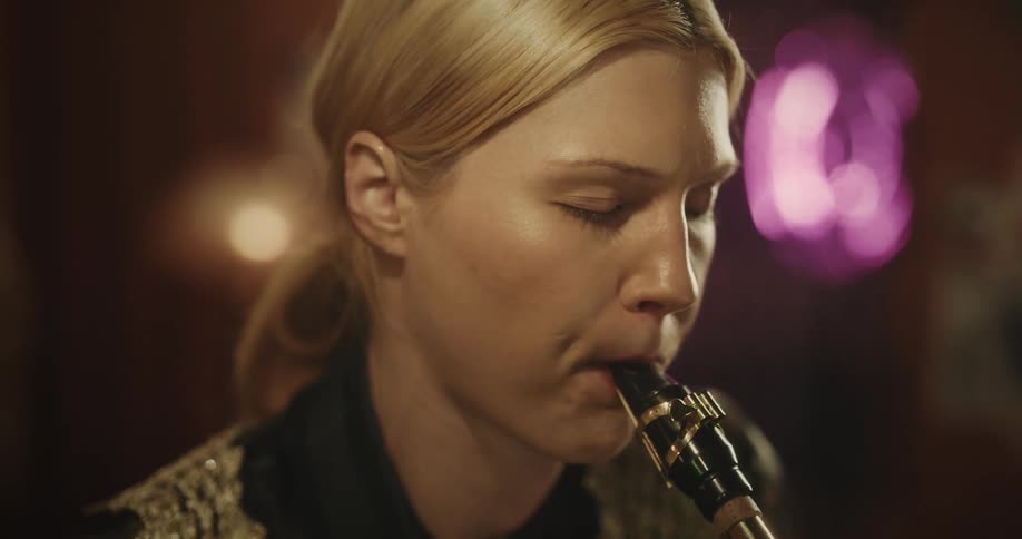 Young blonde woman playing a trumpet indoors