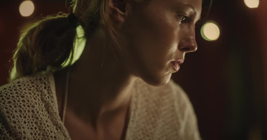 Portrait of a young blonde woman painting on a canvas