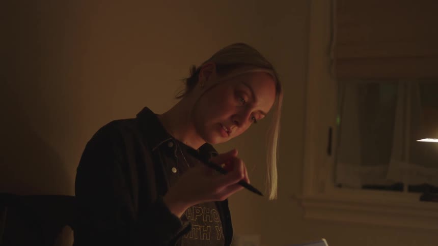 A woman puts down her notebook by her keyboard