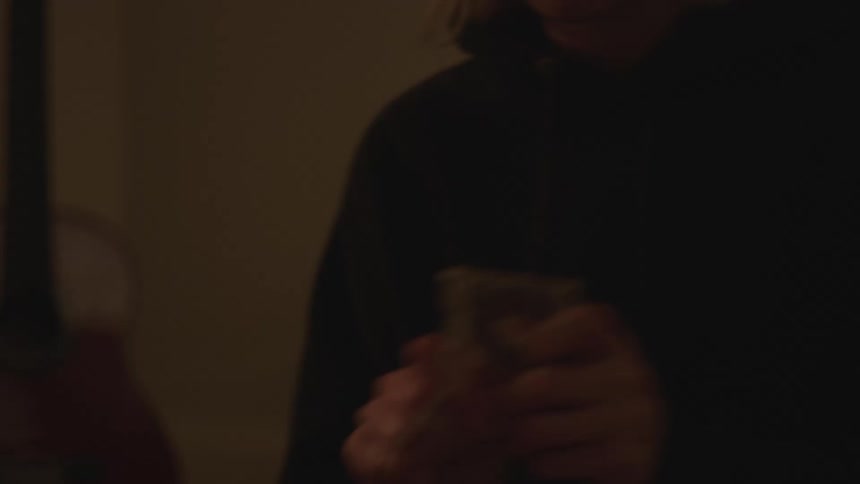 A woman is angry and tearing up playing cards