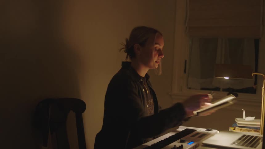 A woman writing to a piano melody