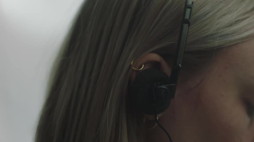 A lady putting on an headset listening to music