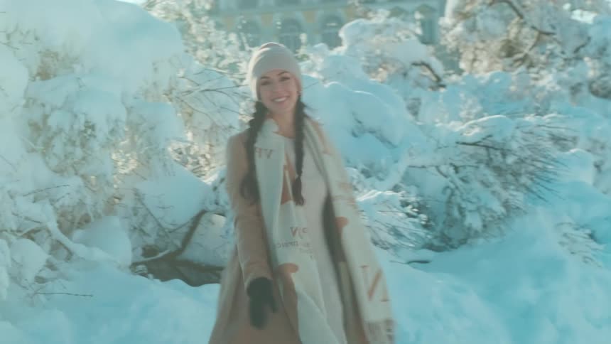 Lady running on a land covered in snow while smiling during the day