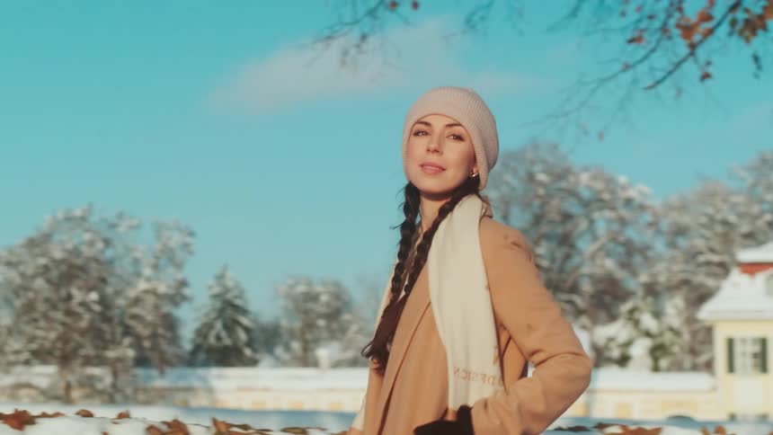 A clip of a lady wearing a winter dress and walking across the street