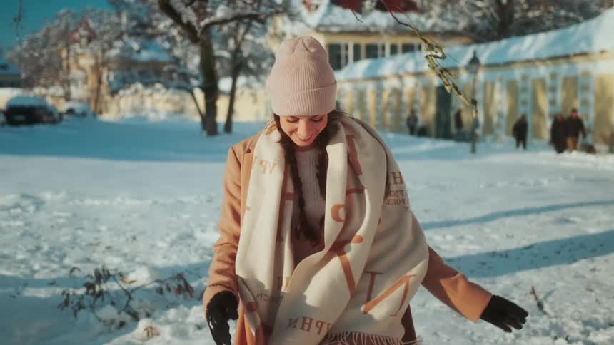 A woman walks up smiling in the snow