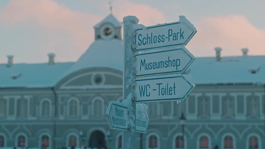 Signs provide directions at snow covered tourist attraction during winter