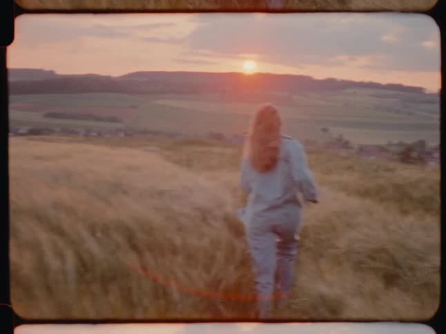 A female running on grass at sunset