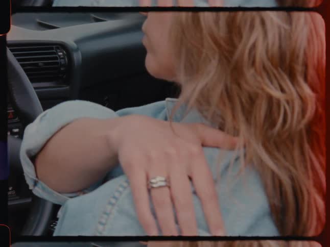 A woman massaging her shoulder in a car