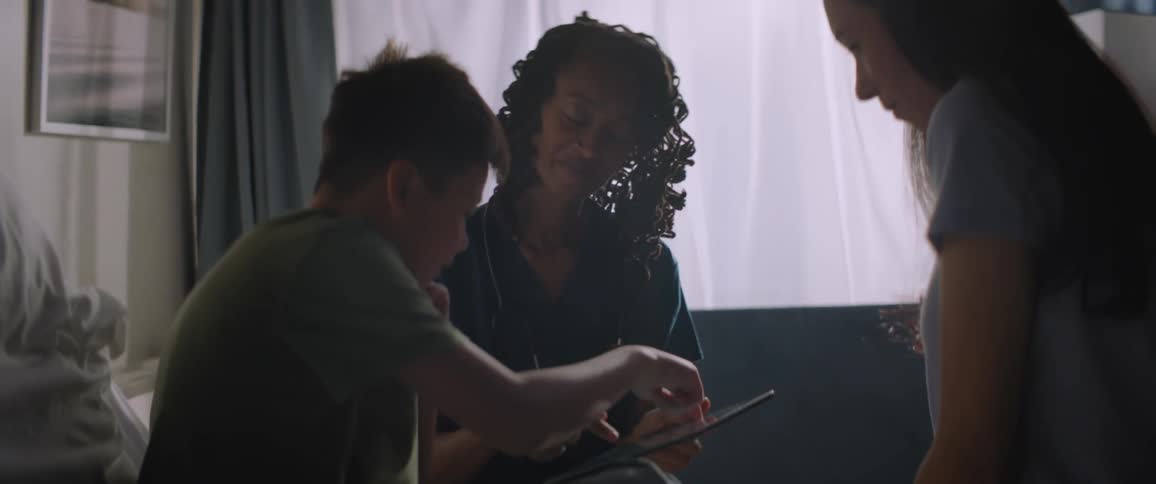 A boy and a doctor reading something on a tablet