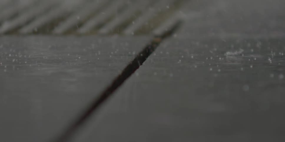 Rain pours down on the sidewalk