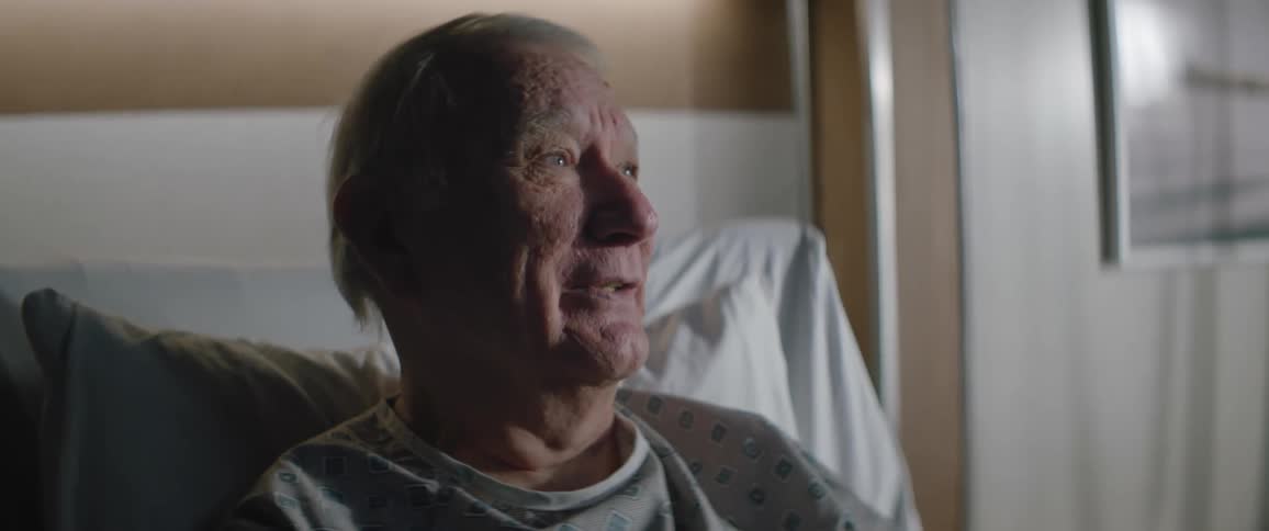 A hospital patient is talking in bed