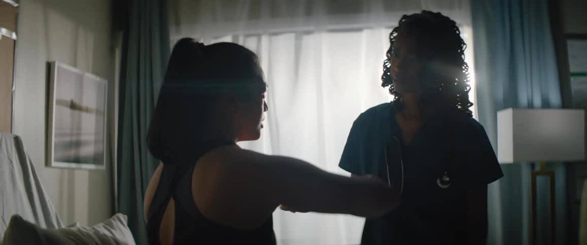 Nurse placing her hands on the shoulder of a patient and having a conversation