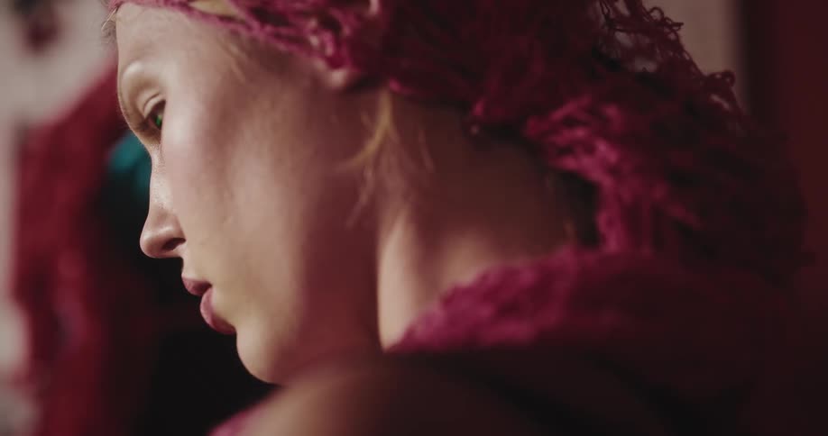 A woman wearing a pink knitted hair scarf