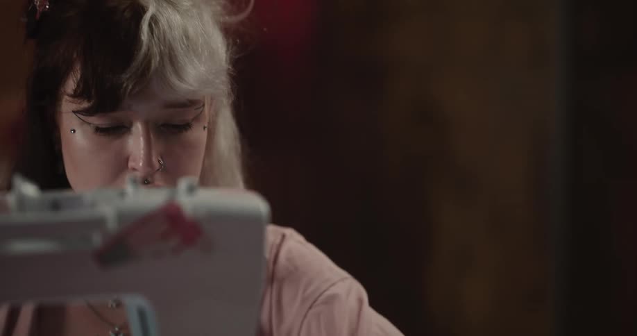 A woman is sewing a cloth in with a sewing machine