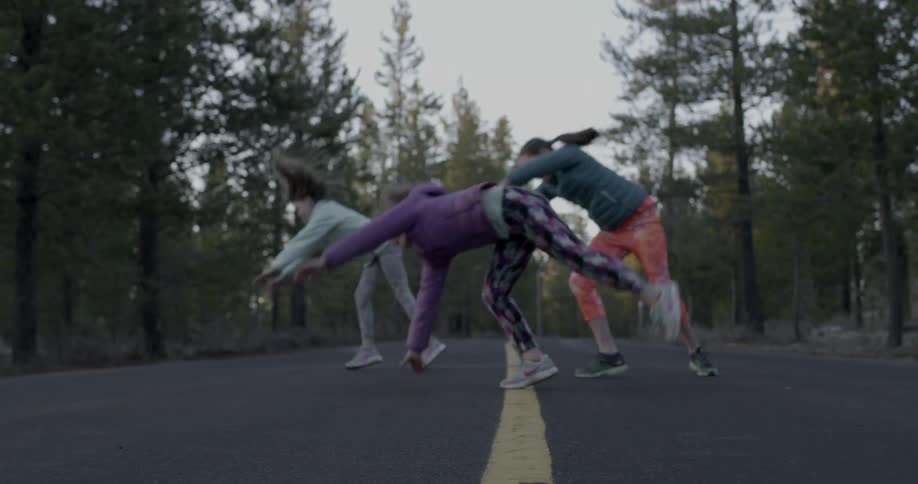 Children perform cartwheels across a street
