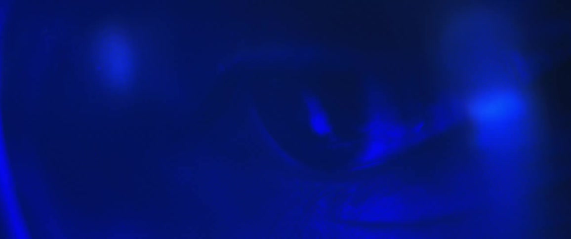 A persons eye is blinking and everything around is in blue color