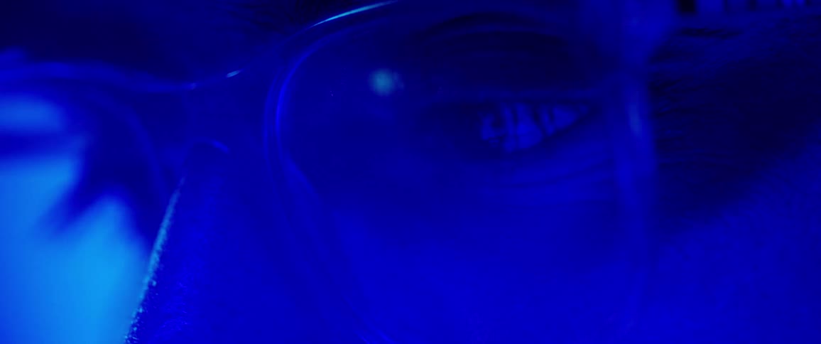A man wearing glasses is blinking