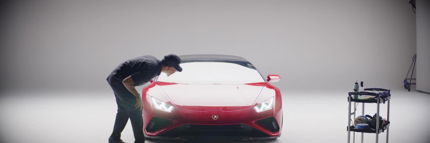 View of a man analyzing the front of a red lamborghini