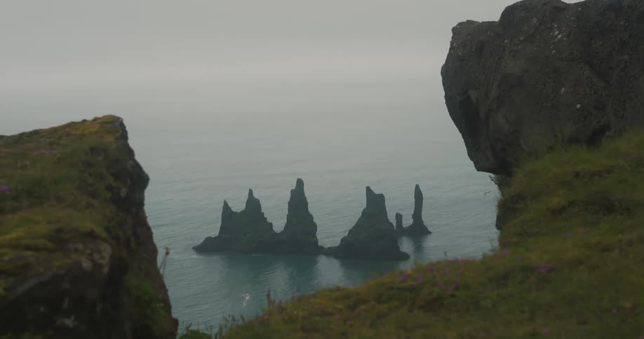 Panorama of mountains and ruins amidst the sea on a cloudy day