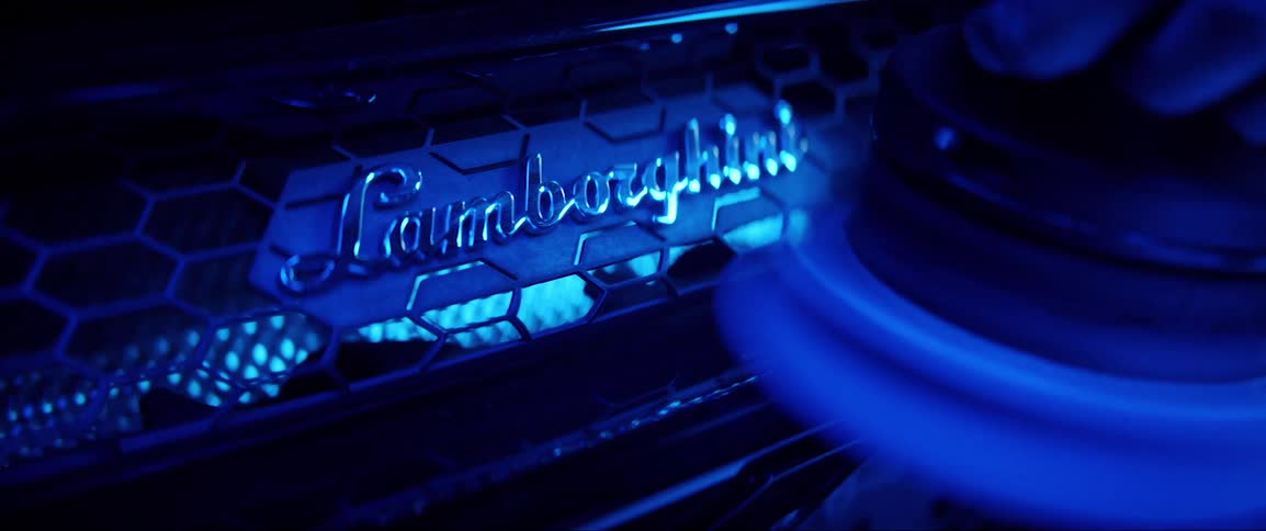 A machine polishes the brand plate of a lamborghini
