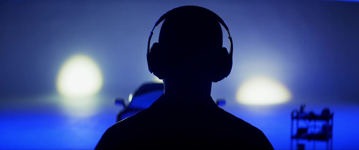 Man facing both away and towards a lamborghini in an indoor studio with lights