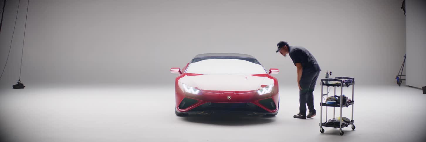 A man examining a red ferrari in a garage