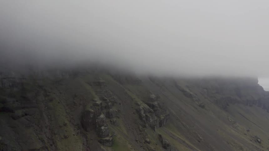 Panorama of a mountain covered by clouds on a serene day