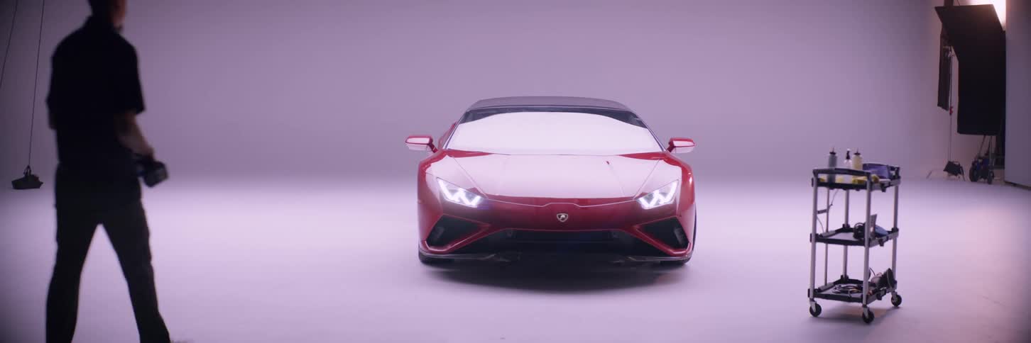 A man walking up to a red ferrari in the garage