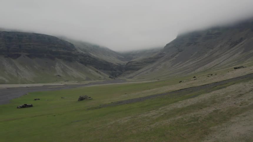 Aerial of a valley between mountains and pastures