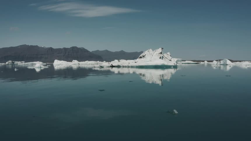 Blocks of arctic ice float in the ocean on a sunny day