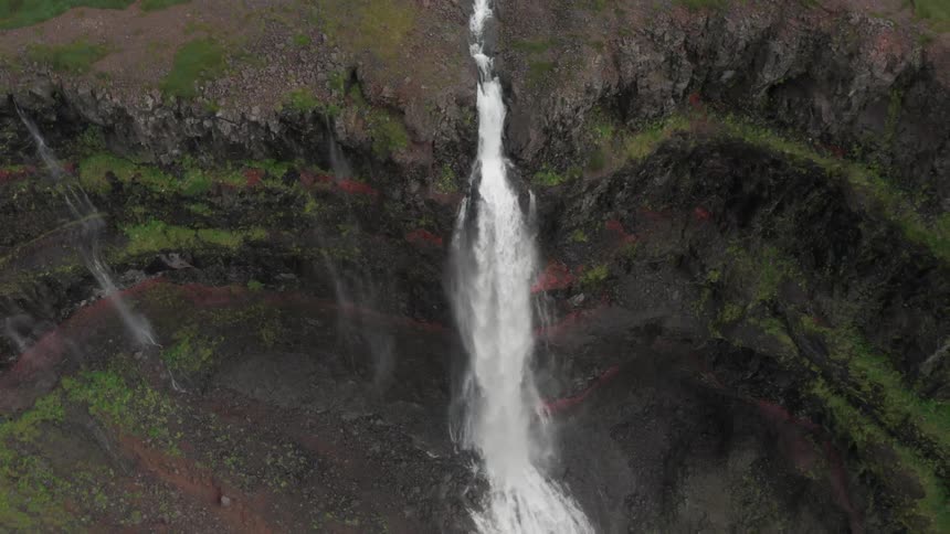 Aerial panorama of a waterfall in free fall amidst a mountain