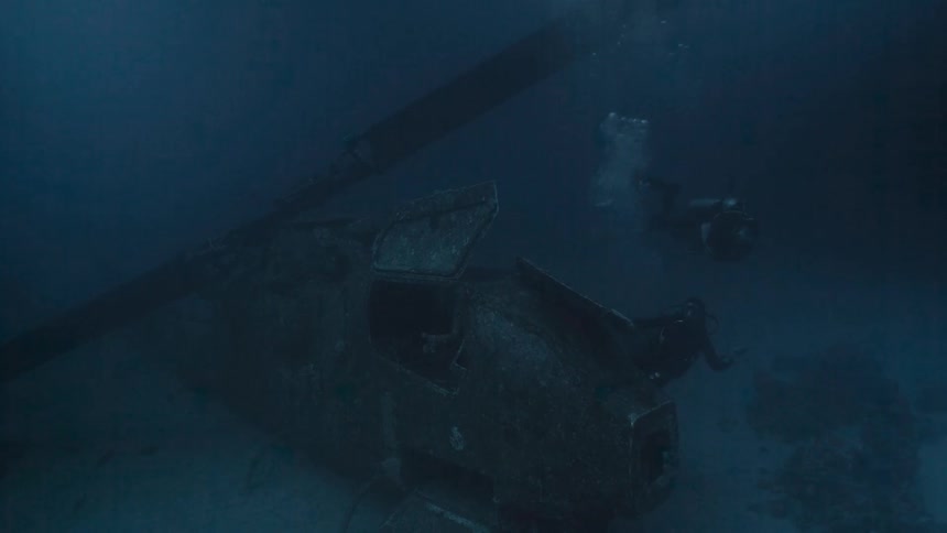 Divers observing a vessel at the bottom of the ocean
