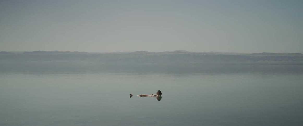 Woman floating in a calm and waveless water at dead sea