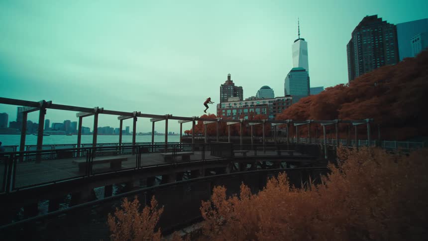 Man jumping on a parkour platform amidst a seaside metropolis