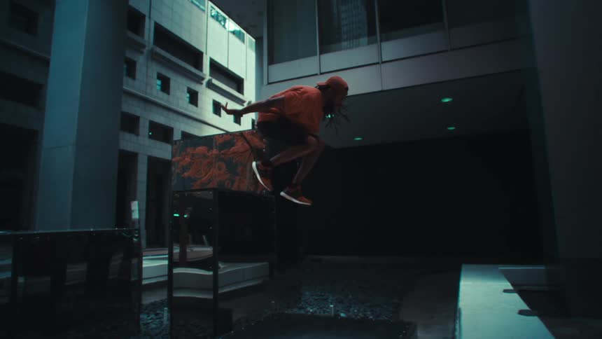 A man doing parkour by jumping over obstacles that have mirrors