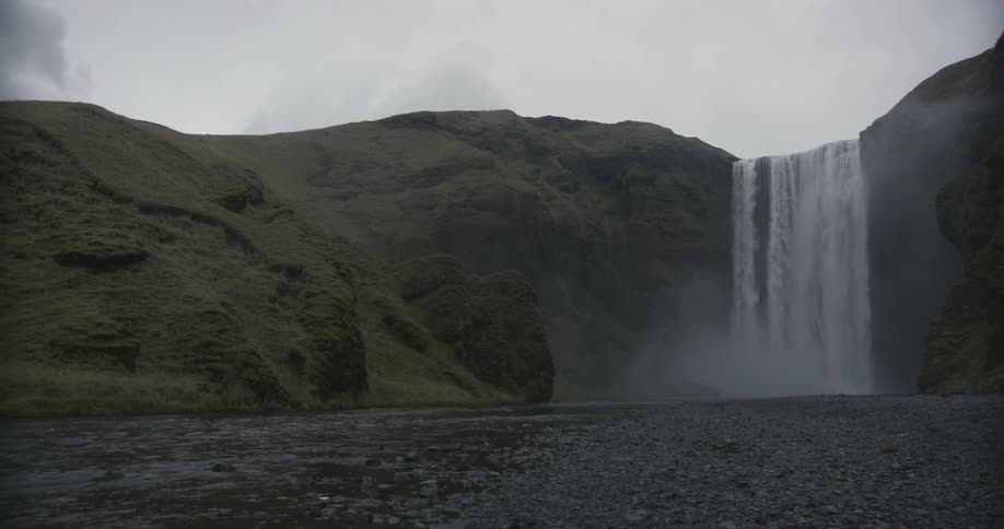 A waterfall splashing into a large lake