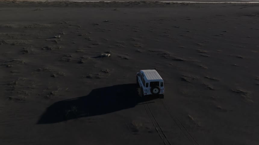 Aerial of a car crossing a desert plain