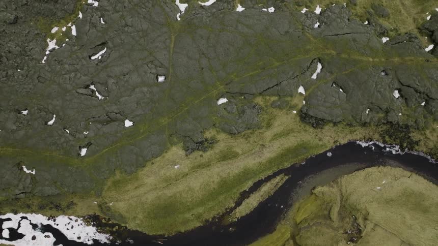 Aerial view of a winding river in the green field