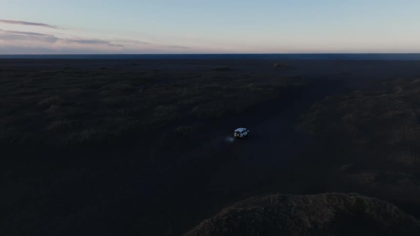 Aerial panorama of a car driving on the ground in the morning