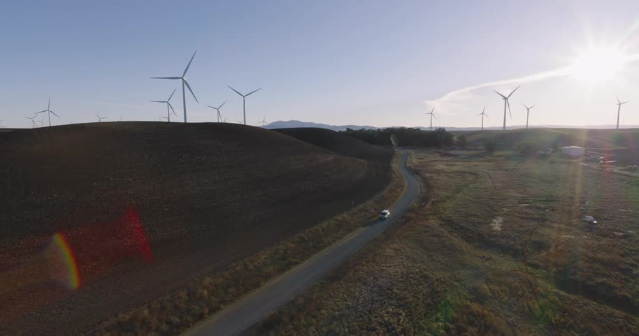 A car driving across a wind farm
