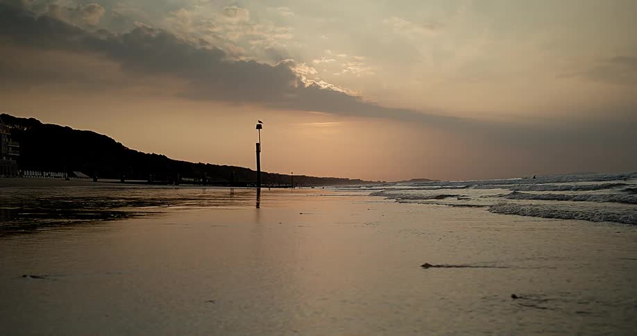 Ocean waves breaking against the beach at sunset
