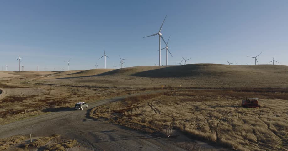 Vehicle driving on a road next to wind energy platforms