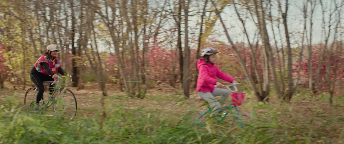 A mother and daughter bicycling through the woods